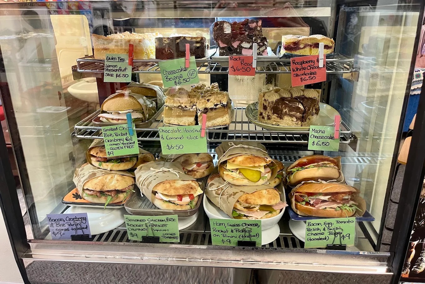 The cafe cabinet stocked with paninis and slices